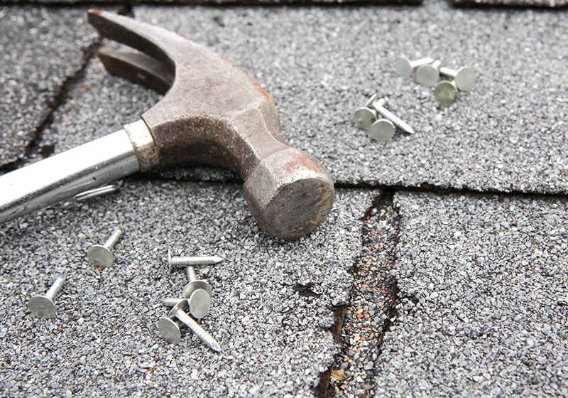 Hammare och spik på tak