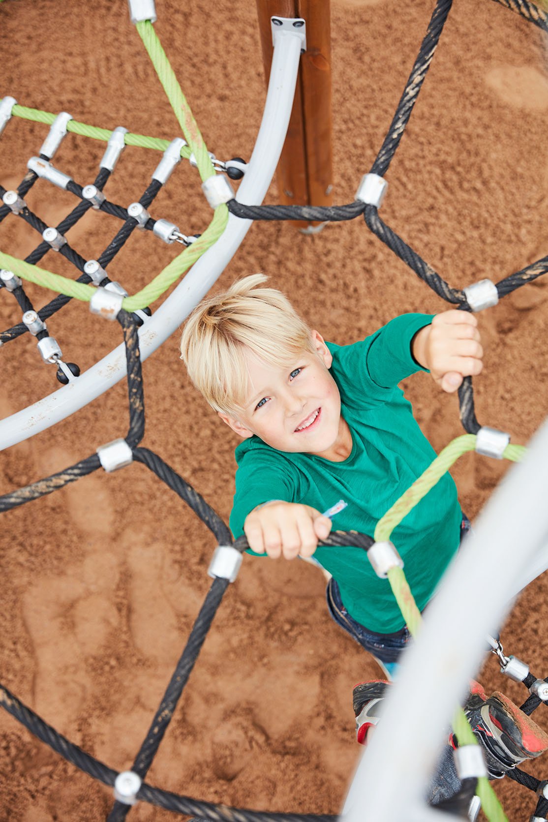 Barn i klättringsnät på lekplats